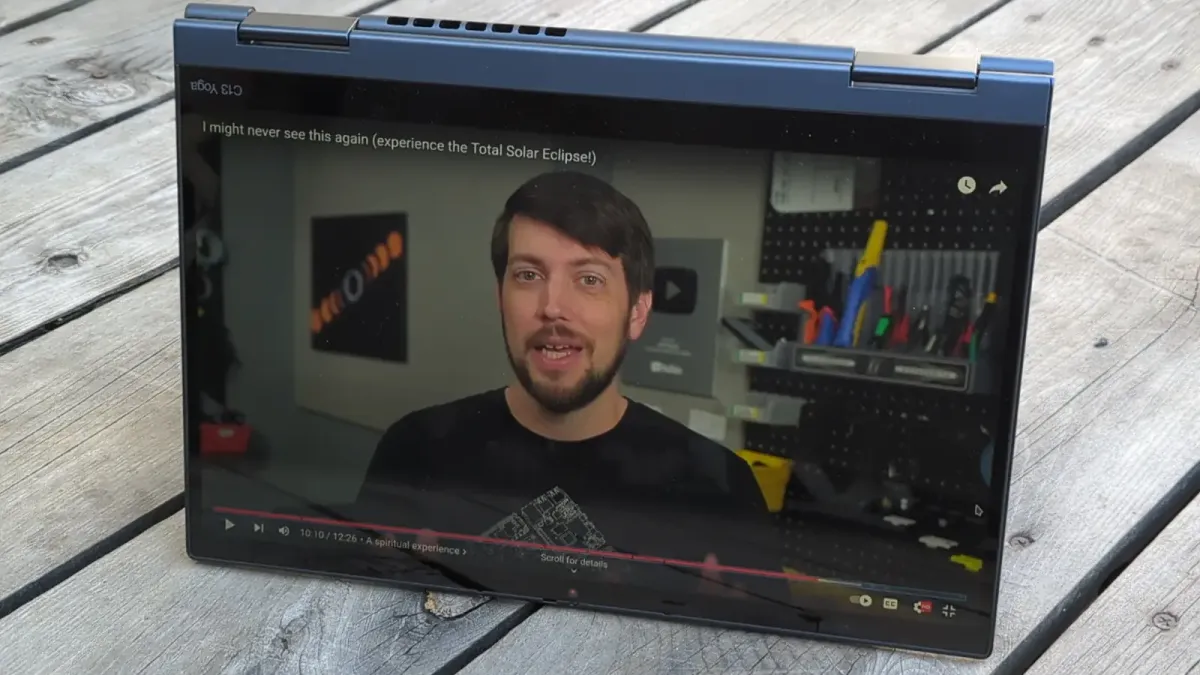 A foldable laptop on a deck, showing a Jeff Geerling video on the screen.